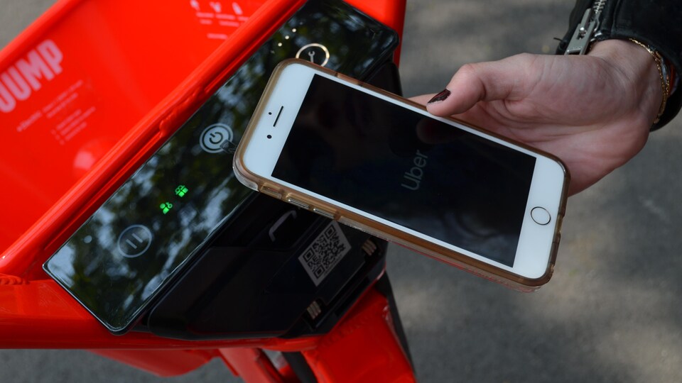 Une bicyclette motorisée Jump et un téléphone intelligent.