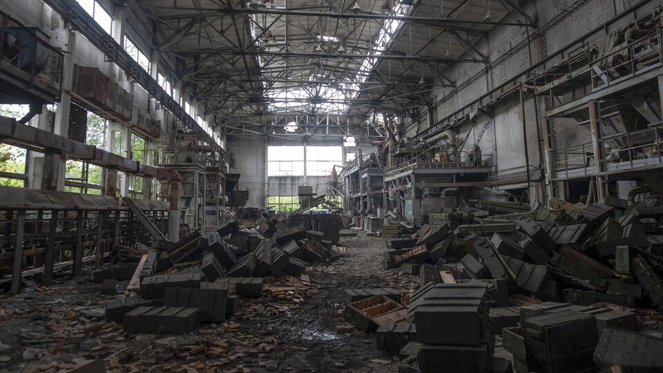 Des caisses éparpillées dans un entrepôt détruit.