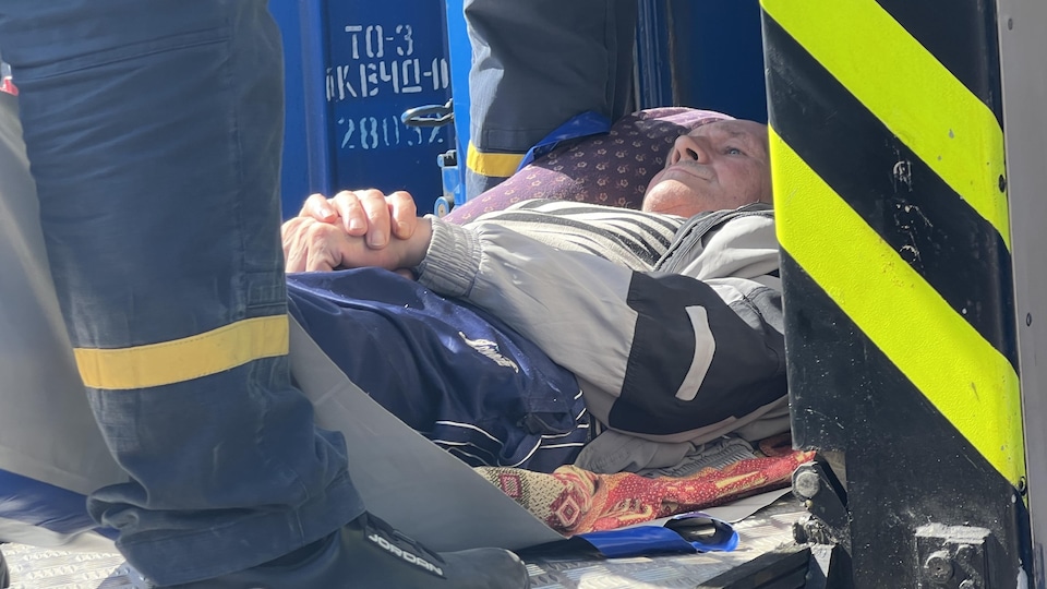 A lying man was brought in by rescuers to board the train.