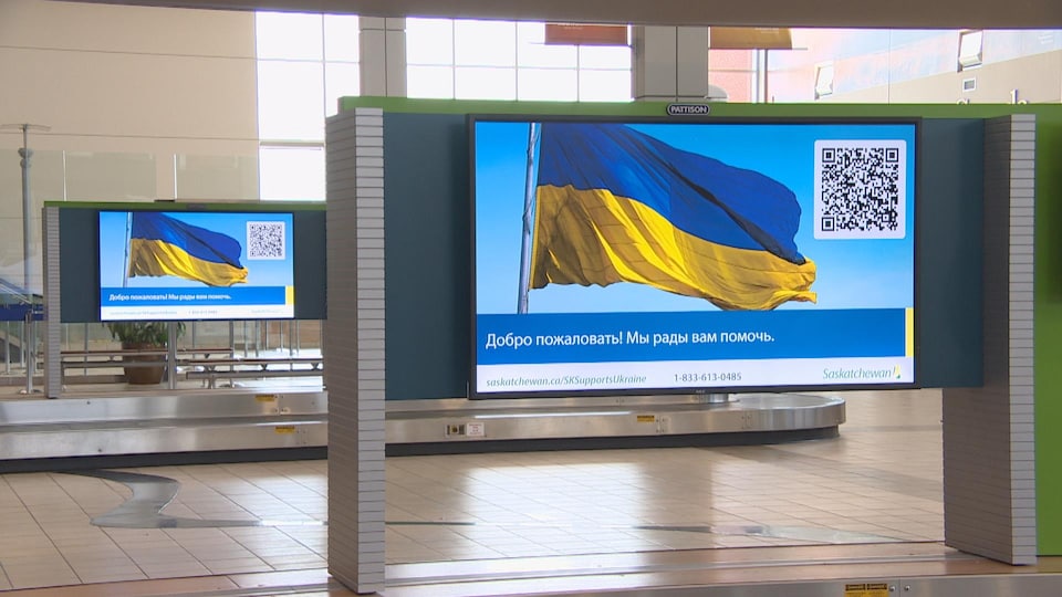 Le drapeau ukrainien sur un grand écran à l'aéroport de Regina.  