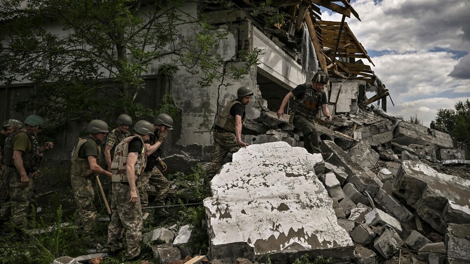 Des soldats sur un site réduit en ruines après des bombardements.