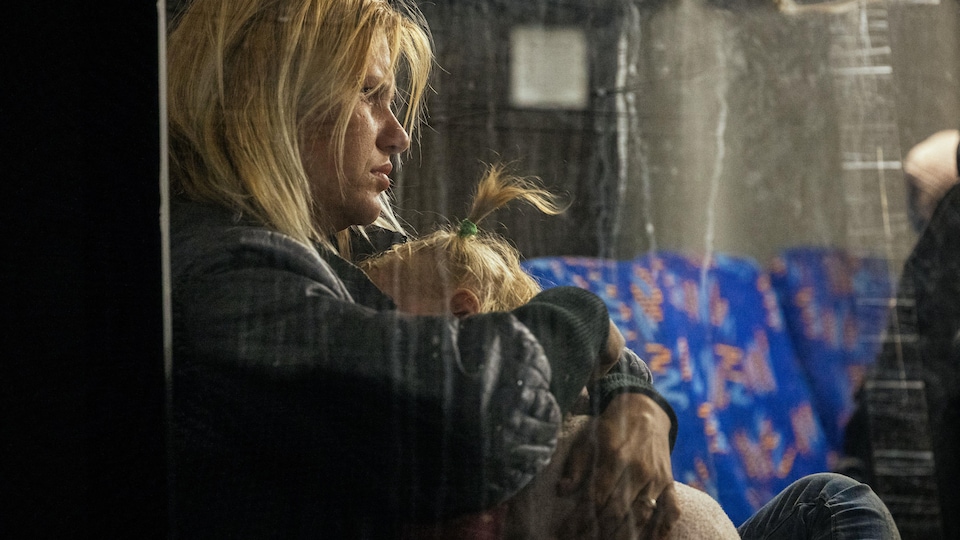 A woman on the bus hugs her child. 