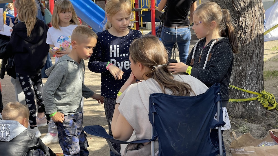 The children, sitting and standing, were talking to themselves.