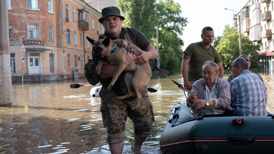 Ukrainian soldiers help residents evacuate a flooded area in Kherson.