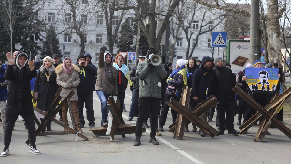 Des gens regroupés autour de hérissons tchèques manifestent dans une rue. 