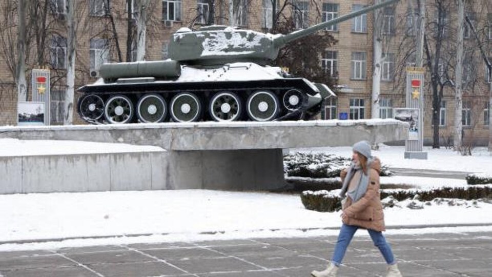 Une jeune femme passe devant un char T-34 soviétique de la Seconde Guerre mondiale, le 25 janvier 2022 à Kiev, en Ukraine. 