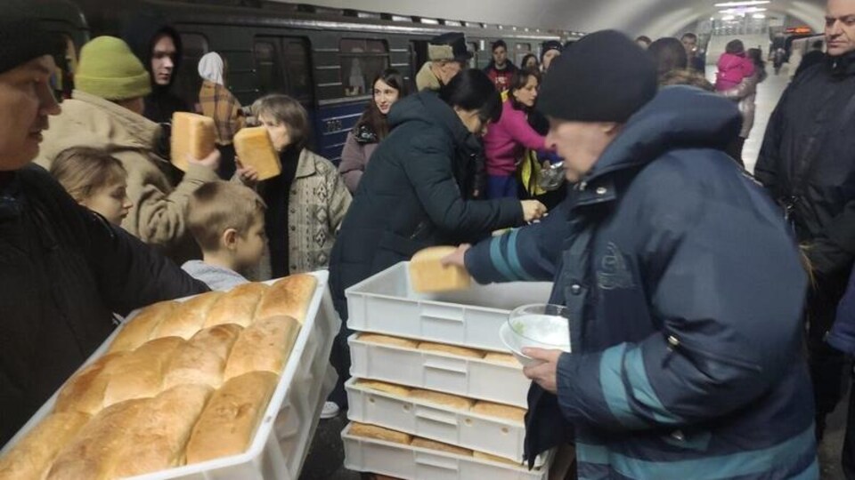 Des bénévoles distribuent du pain.