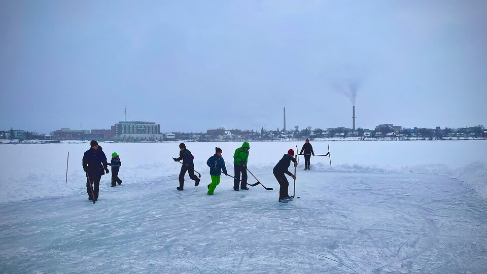 Dzieci grają w hokeja na jeziorze Osisko.