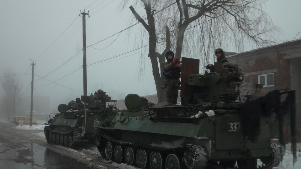 Des membres des forces armées ukrainiennes à bord de véhicules blindés près de la ville d'Avdiyivka.