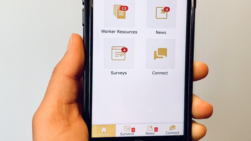 Une application mobile sur laquelle on peut voir des icônes en anglais: Ressources des employés, Nouvelles, Sondages et Connectez-vous.