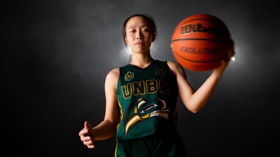 Une joueuse de basketball porte l'uniforme des Timberwolves de l'UNBC.