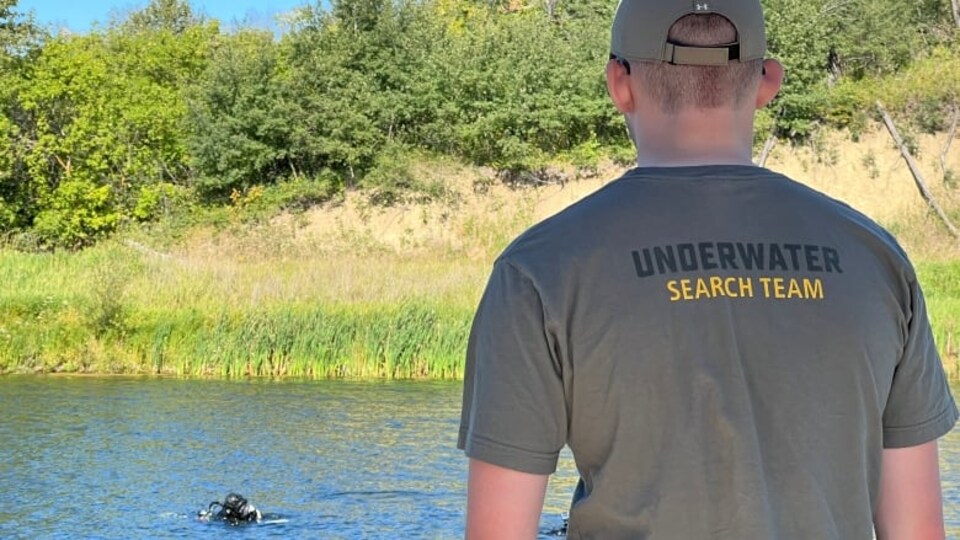 Un homme de dos fait face à une rivière.