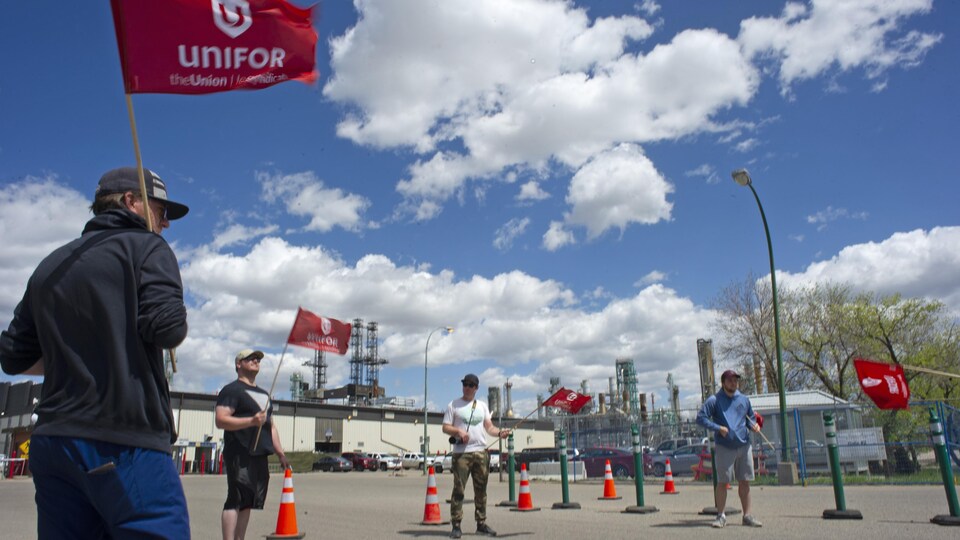 Des membres d'Unifor avec des drapeaux sont dehors tout près du site de la raffinerie Co-op de Regina.