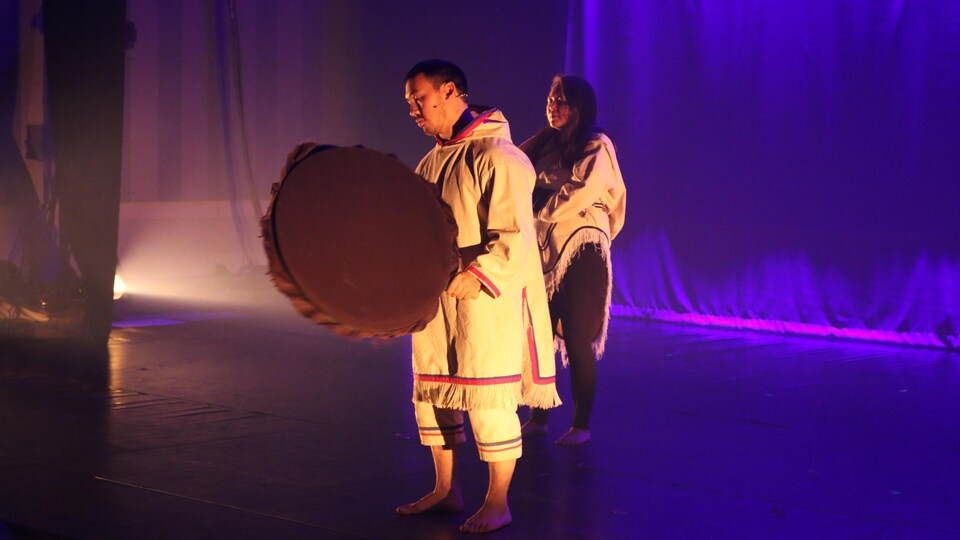 Des artistes de cirque en tenue inuit se tiennent sur une scène.