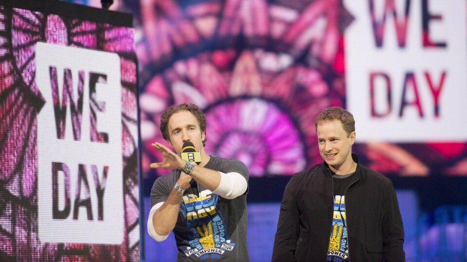 Les deux hommes sur une scène lors d'un événement WE DAY.