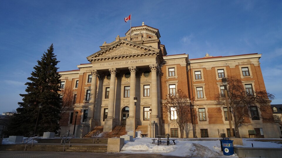 Un bâtiment de l'Université du Manitoba avec des colonnes au crépuscule.