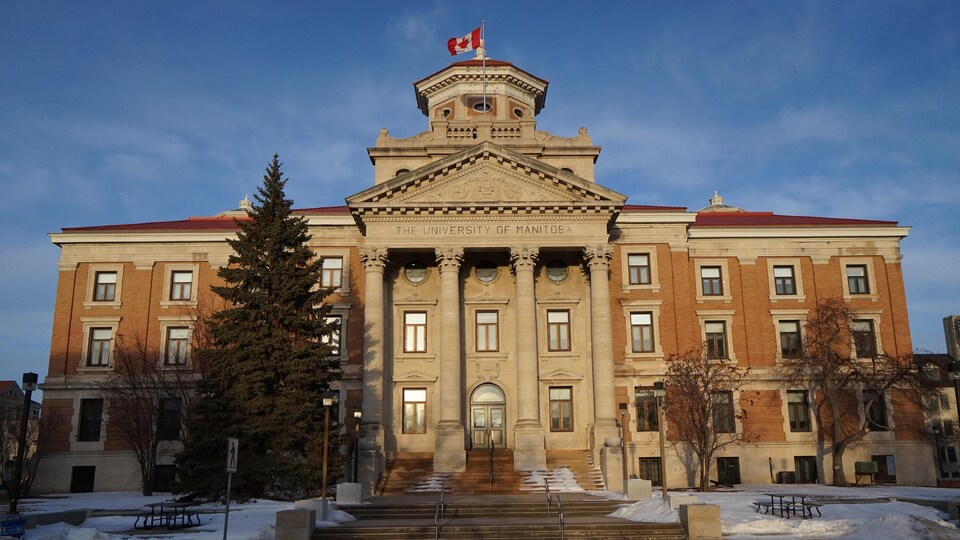 Un grand bâtiment avec des colonnes au crépuscule. 