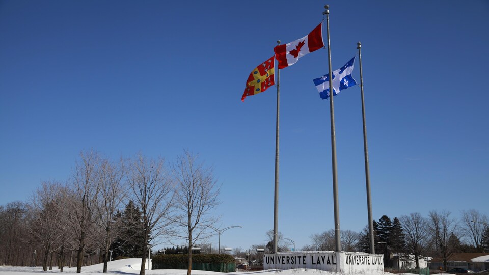L'Université Laval en hiver. Le drapeau de l'université flotte aux côtés de l'unifolié et du fleurdelisé.