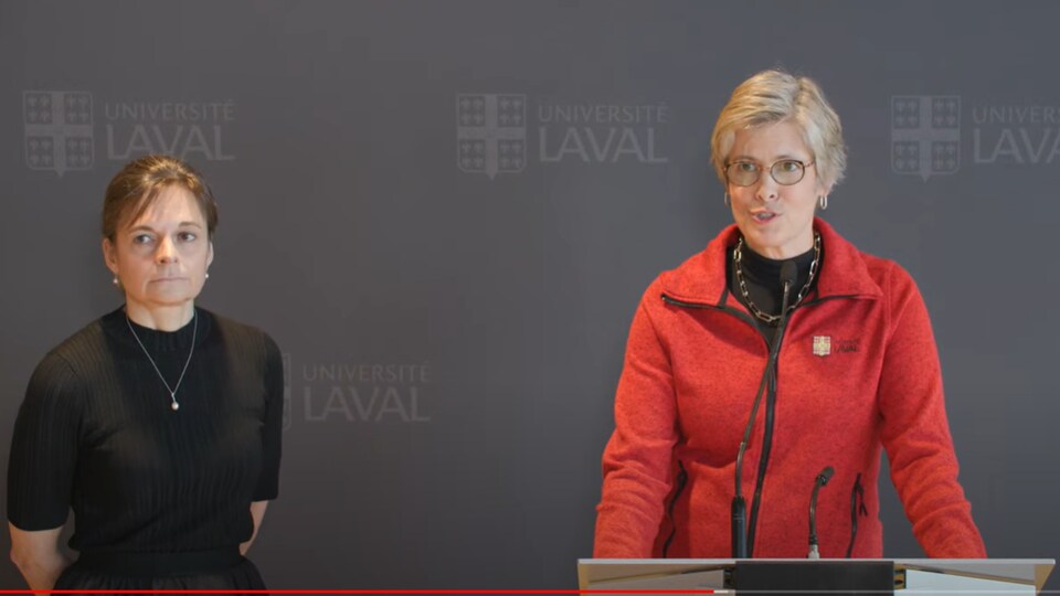 En point de presse devant une toile à l'image de l'Université Laval, la rectrice est accompagnée à sa droite de la vice-rectrice. 