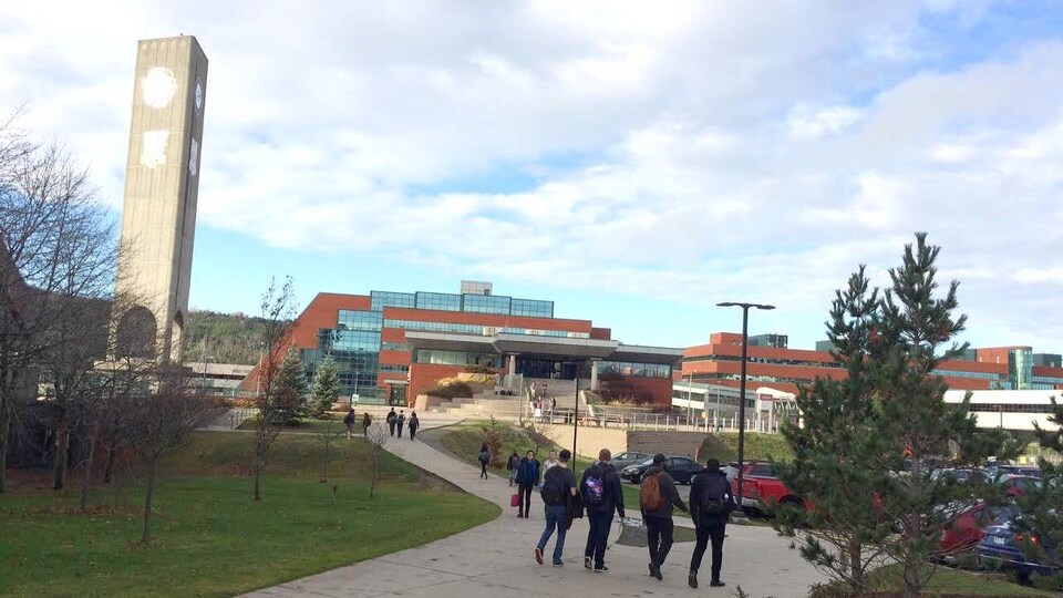 Des étudiants marchent en direction d'un pavillon dans un campus.