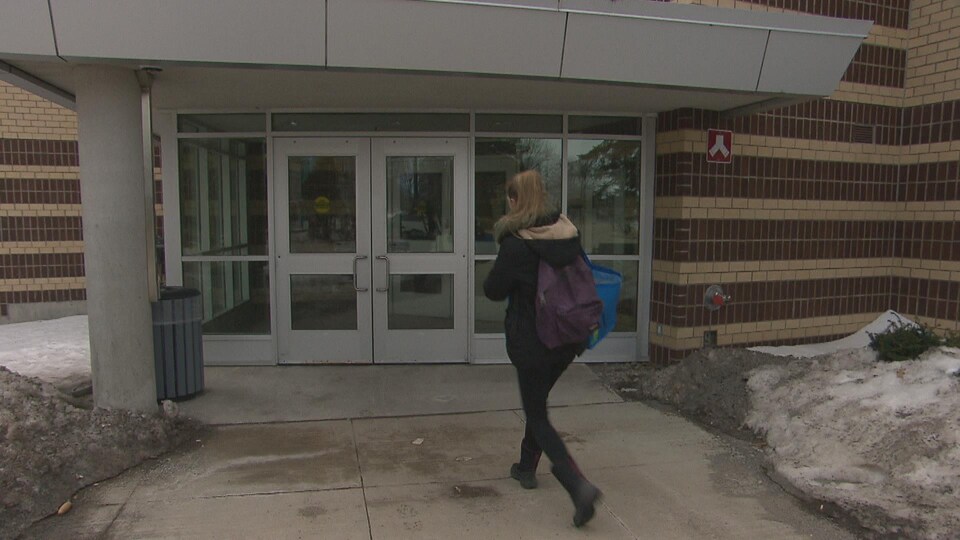 Une étudiante entre dans un édifice du campus de Moncton.