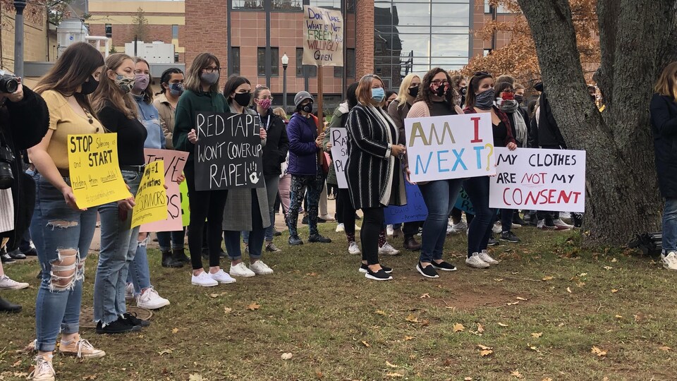 Des manifestantes brandissent des pancartes dénonçant des agressions sexuelles.