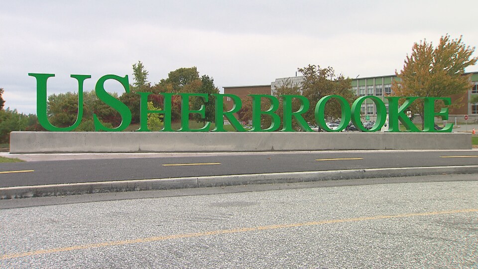 Les lettres USHERBROOKE sont affichées sur le bord d'une piste cyclable. 