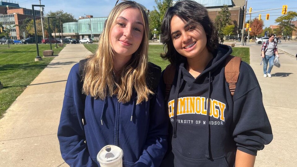 Deux jeunes femmes posent sur le campus.
