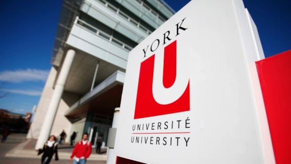 Photo d'étudiants marchant près de l'enseigne de l'Université York.