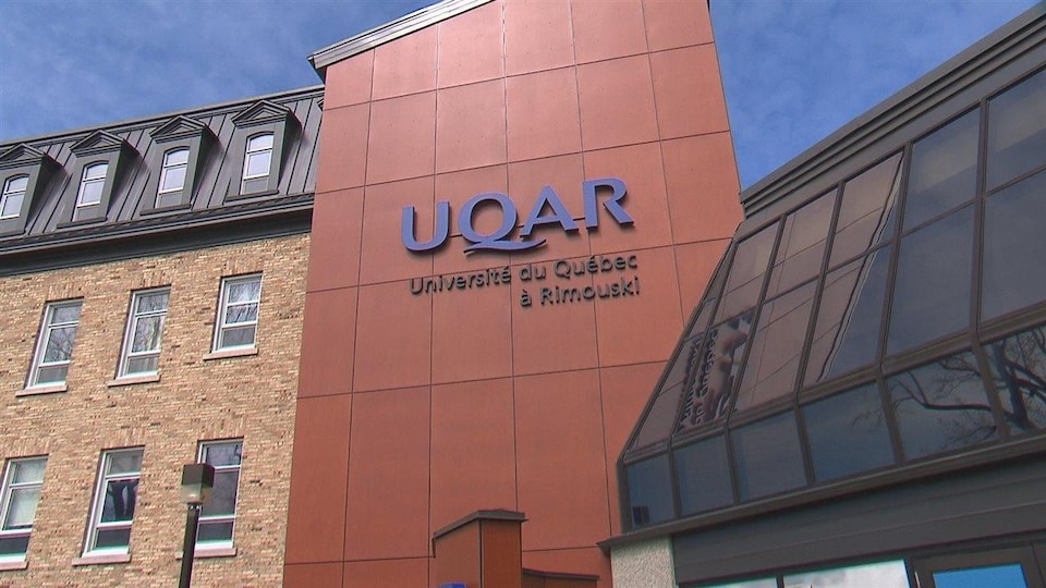 Le logo de l'université sur la façade de l'immeuble.