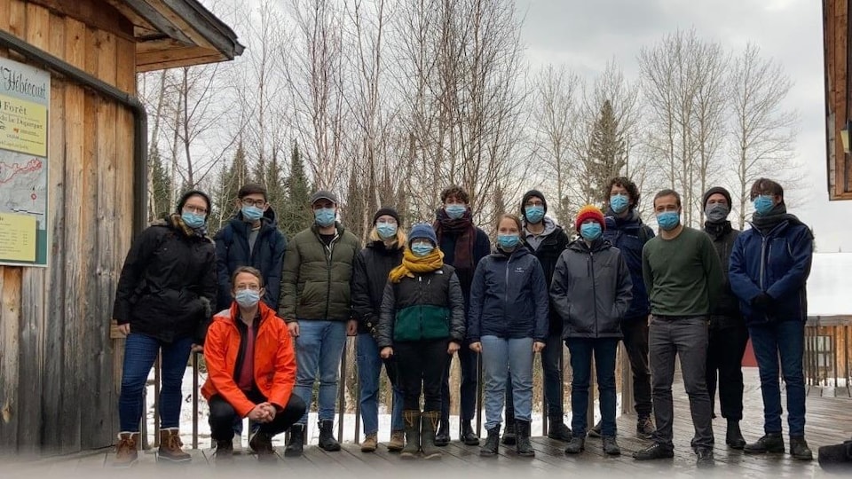 Une quinzaine de personnes posent à côté d'un chalet dans les sentiers Hébécourt.