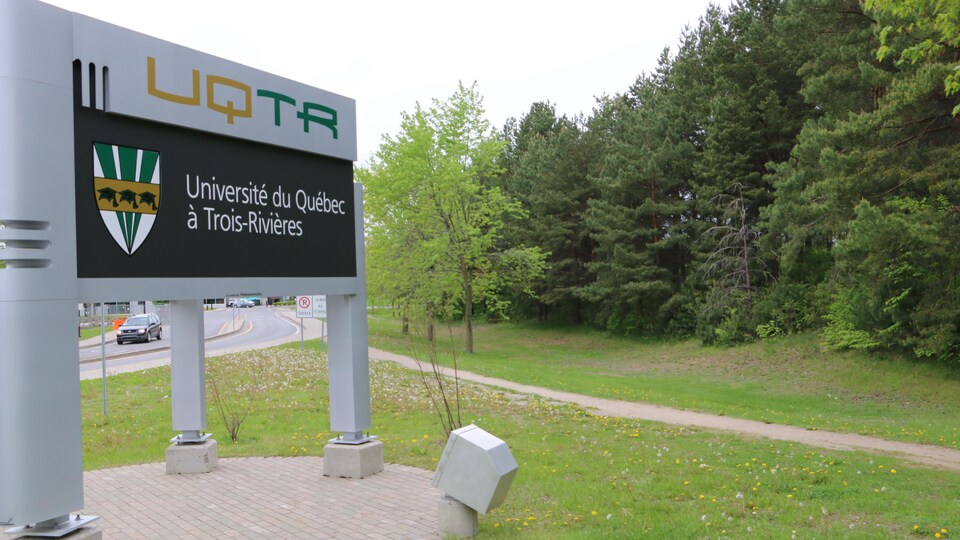 La façade de l'UQTR devant des arbres. 