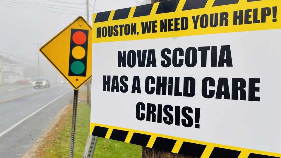 Une affiche disant au premier ministre Tim Houston qu'il y a une crise dans les garderies en Nouvelle-Écosse.