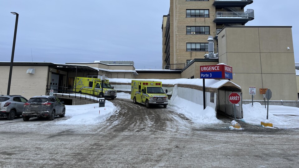 Un hôpital et des ambulances devant l'entrée d'une urgence.
