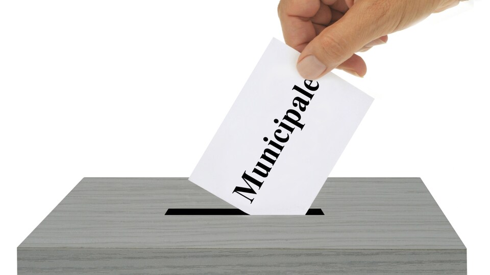 Un électeur dépose un bulletin de vote dans une boîte de scrutin.