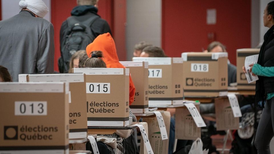 Un bureau de vote au Québec, où l'on voit plusieurs urnes. 