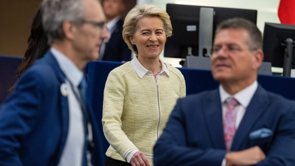 Ursula von der Leyen, souriante, marche dans une enceinte.