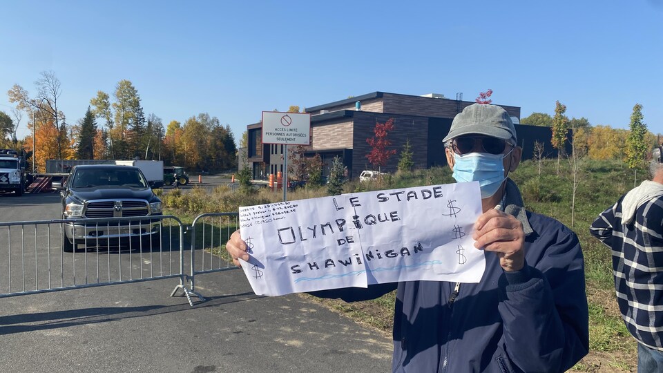 Un manifestant tient une affiche devant l'usine de traitement de l'eau.