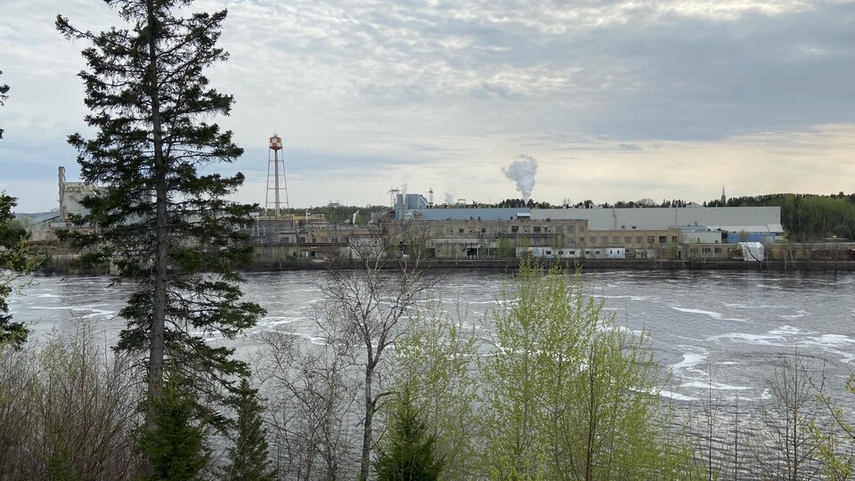 Une usine vue de l'autre rive d'une rivière.
