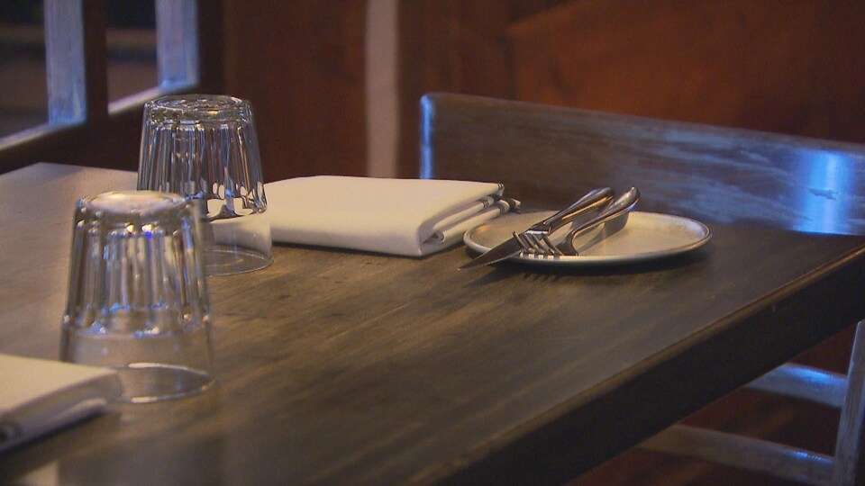 Des ustensiles, des verres et des serviettes sur une table.