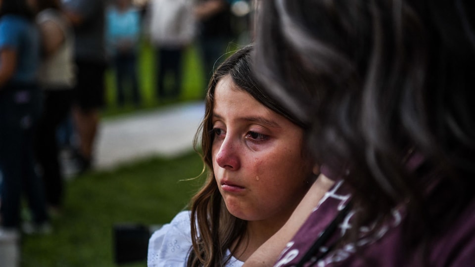 A girl in tears, looking into space.