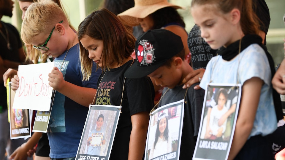 The children watched a minute of silence, lowering their heads.  On their necks, pictures of various victims.