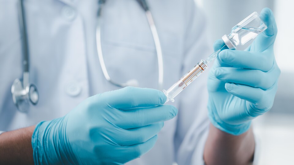 Un infirmier remplit une seringue avec le vaccin contre la COVID-19.