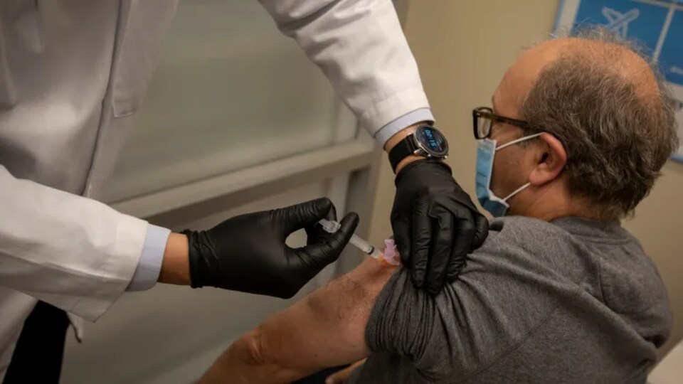 Un homme se fait vacciner contre la grippe.