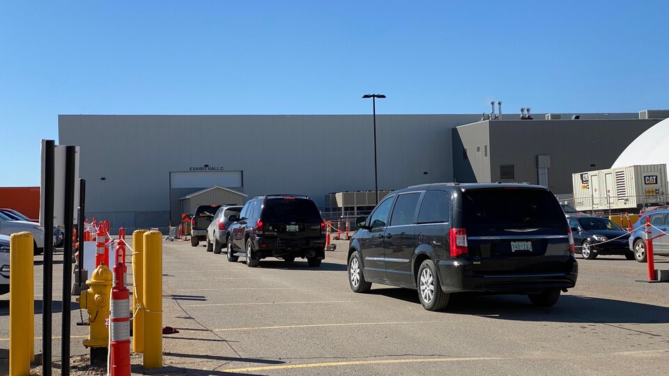 Des voitures sont en file en attente de pouvoir entrer dans la clinique au volant à Regina pour que les occupants puissent se faire vacciner.