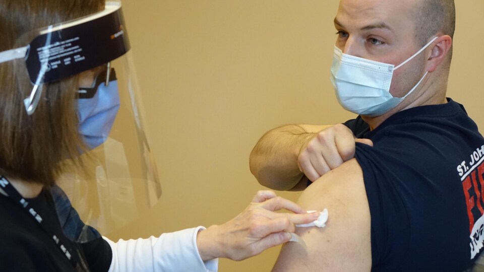 Un homme se fait vacciner.