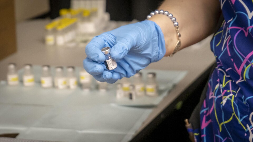 Une main tient une fiole d'un vaccin contre la COVID-19.