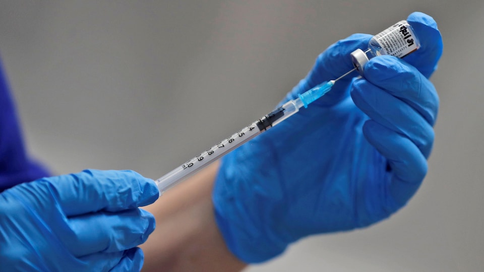 Une infirmière tient une fiole du vaccin contre la COVID-19 de Pfizer-BioNTech.