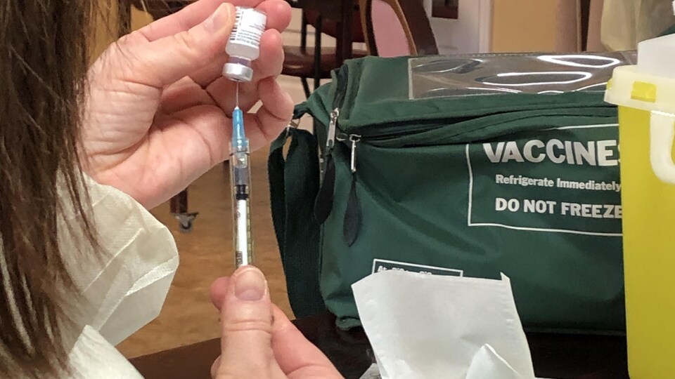 Une infirmière prépare une injection du vaccin de COVID-19.