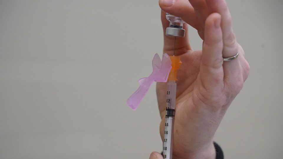 Une infirmière prépare une injection du vaccin contre la COVID-19.
